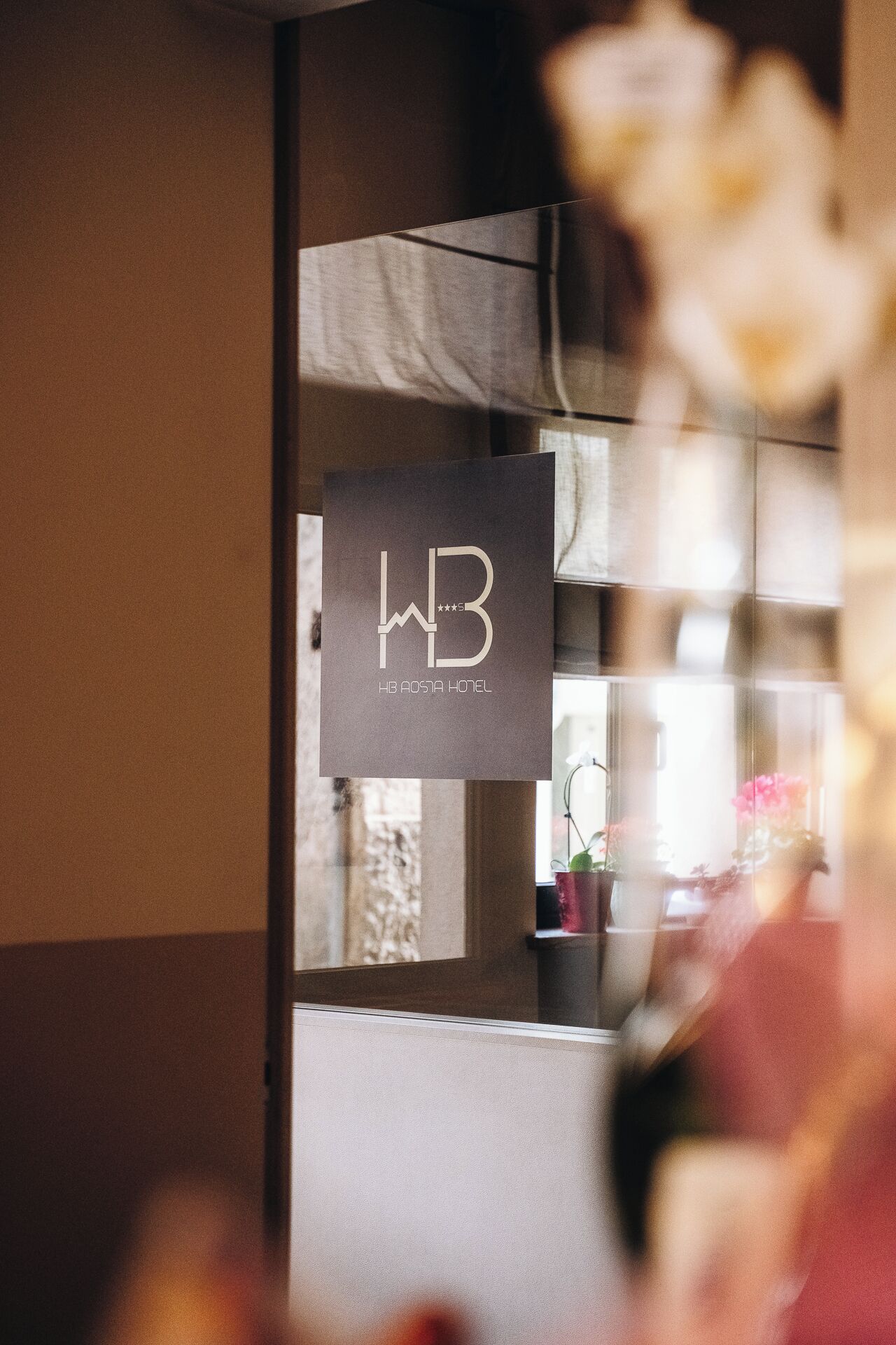 A hotel sign with the logo 'HB' and the name 'HB Aosta Hotel'.