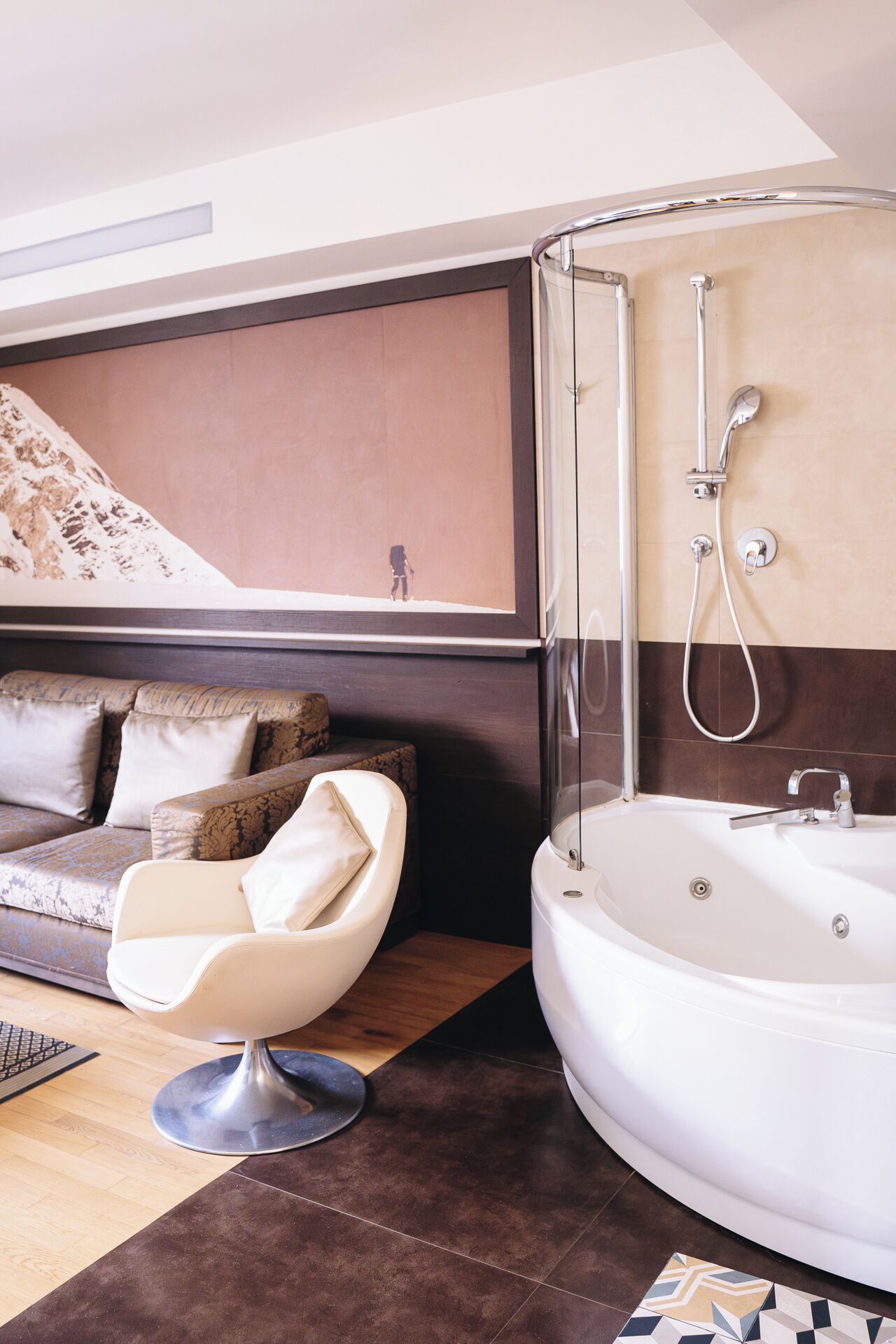 Une salle de bain moderne avec une baignoire, une douche et un canapé dans l’espace de vie adjacent.