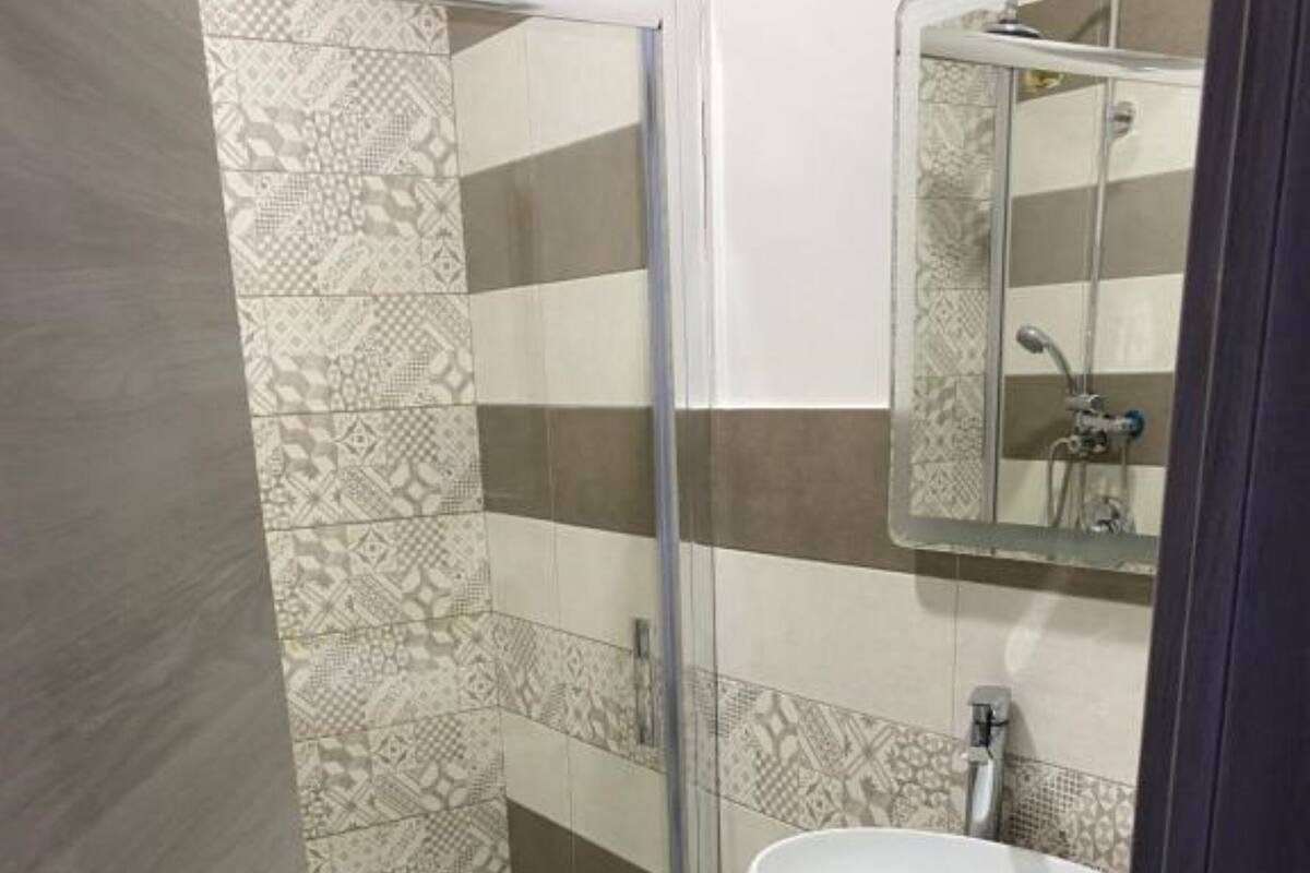 A bathroom with a shower, a sink, and a toilet.