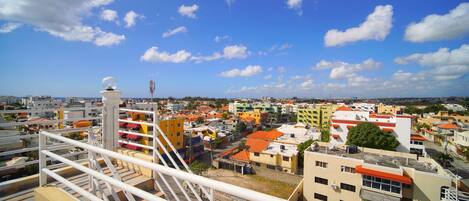 A cityscape with a variety of buildings, including a prominent white structure with a spherical top, possibly a communication tower, and a mix of residential and commercial buildings with colorful facades.