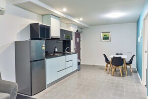A modern kitchen with a built-in refrigerator, a stove, and a dining area with a table and chairs.
