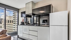 A modern kitchen with a large window, stainless steel appliances, and a city view. - Pegasus Apart'Hotel (Melbourne)