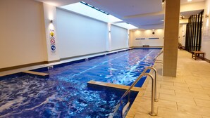 A swimming pool with a 1.2m depth sign, tiled walls, and a wooden floor. - Pegasus Apart'Hotel (Melbourne)