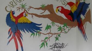 A wall with a bird illustration and the text "Cariari Bed & Breakfast".