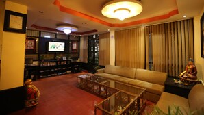 A living room with a sofa, coffee table, and television. - Hotel Buddha Land (Kathmandu)