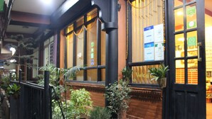 A traditional building with large windows, potted plants, and a brick facade. - Hotel Buddha Land (Kathmandu)