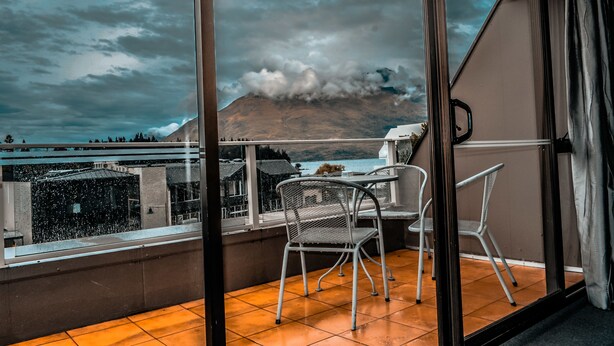 Un balcon avec vue sur une montagne et un plan d’eau.