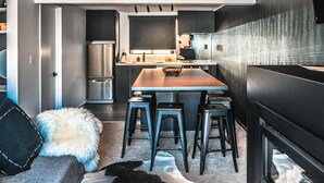Une cuisine moderne dotée d’un îlot central, de tabourets de bar et d’un réfrigérateur.