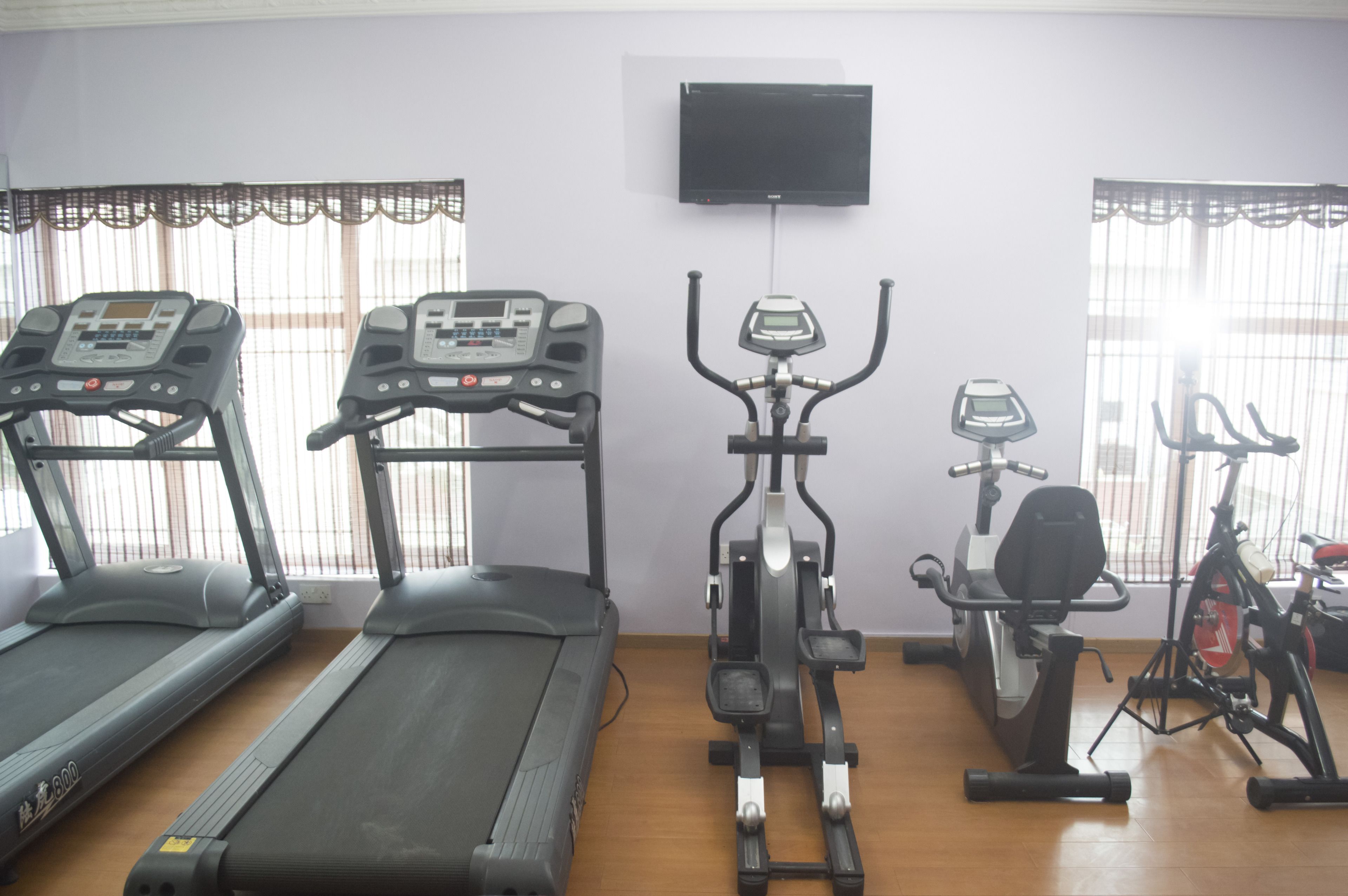 A gym with treadmills, an elliptical, and a stationary bike.