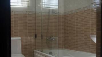 Ein Badezimmer mit Duschkabine, Toilette und Badewanne.