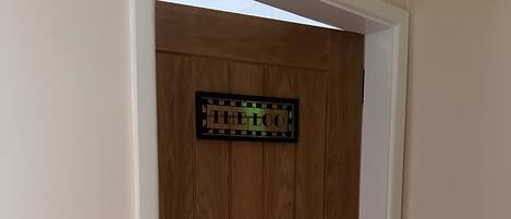 A wooden door with a sign that reads "THE LOO".