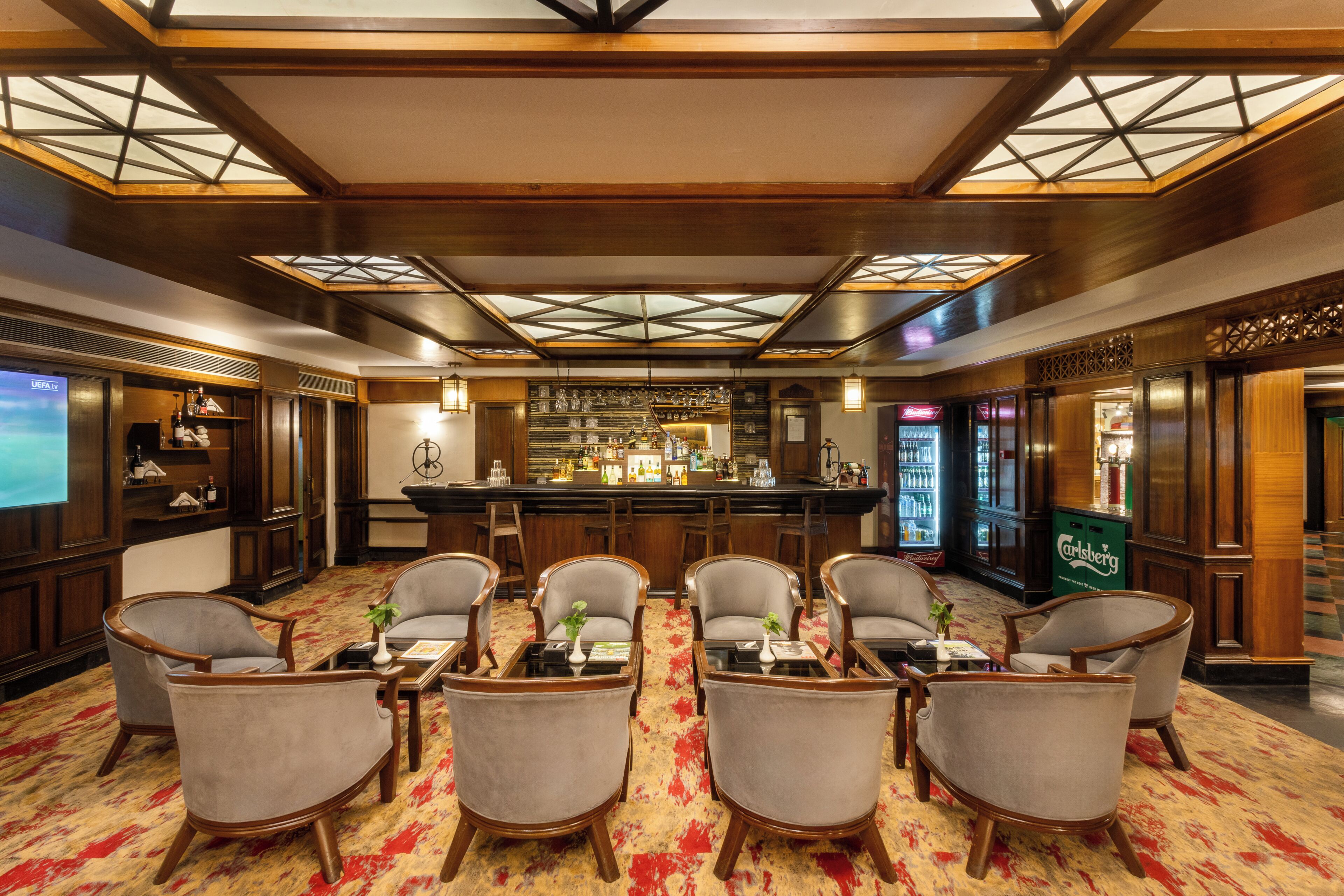 A hotel lobby with a bar area, seating arrangements, and a large window.