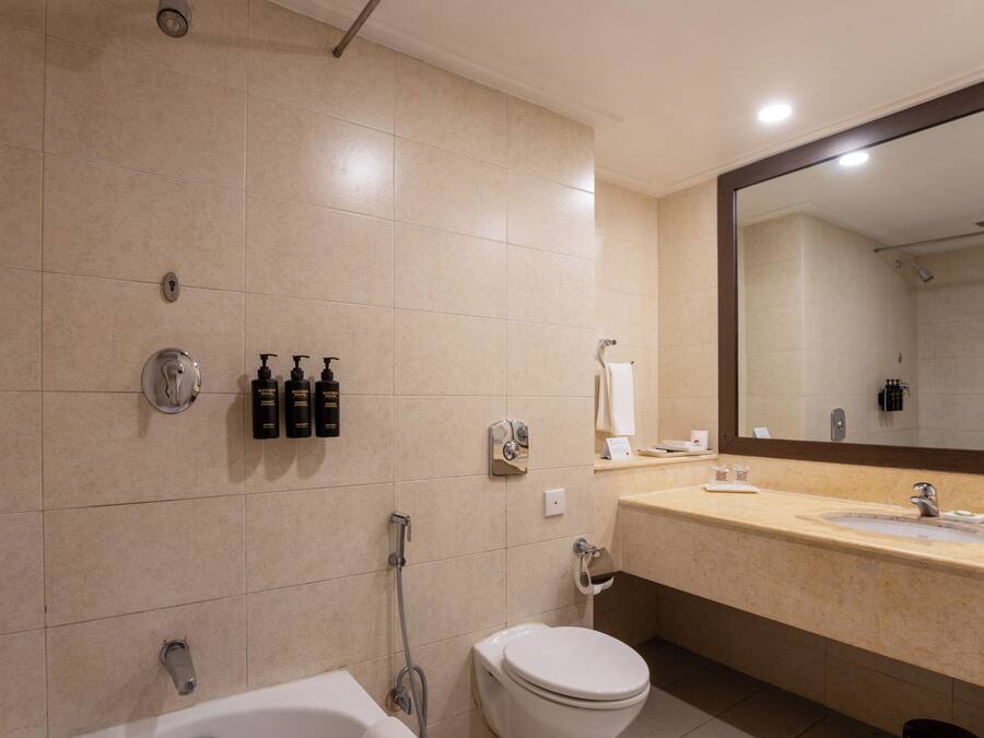 A modern bathroom with a bathtub, toilet, and sink.