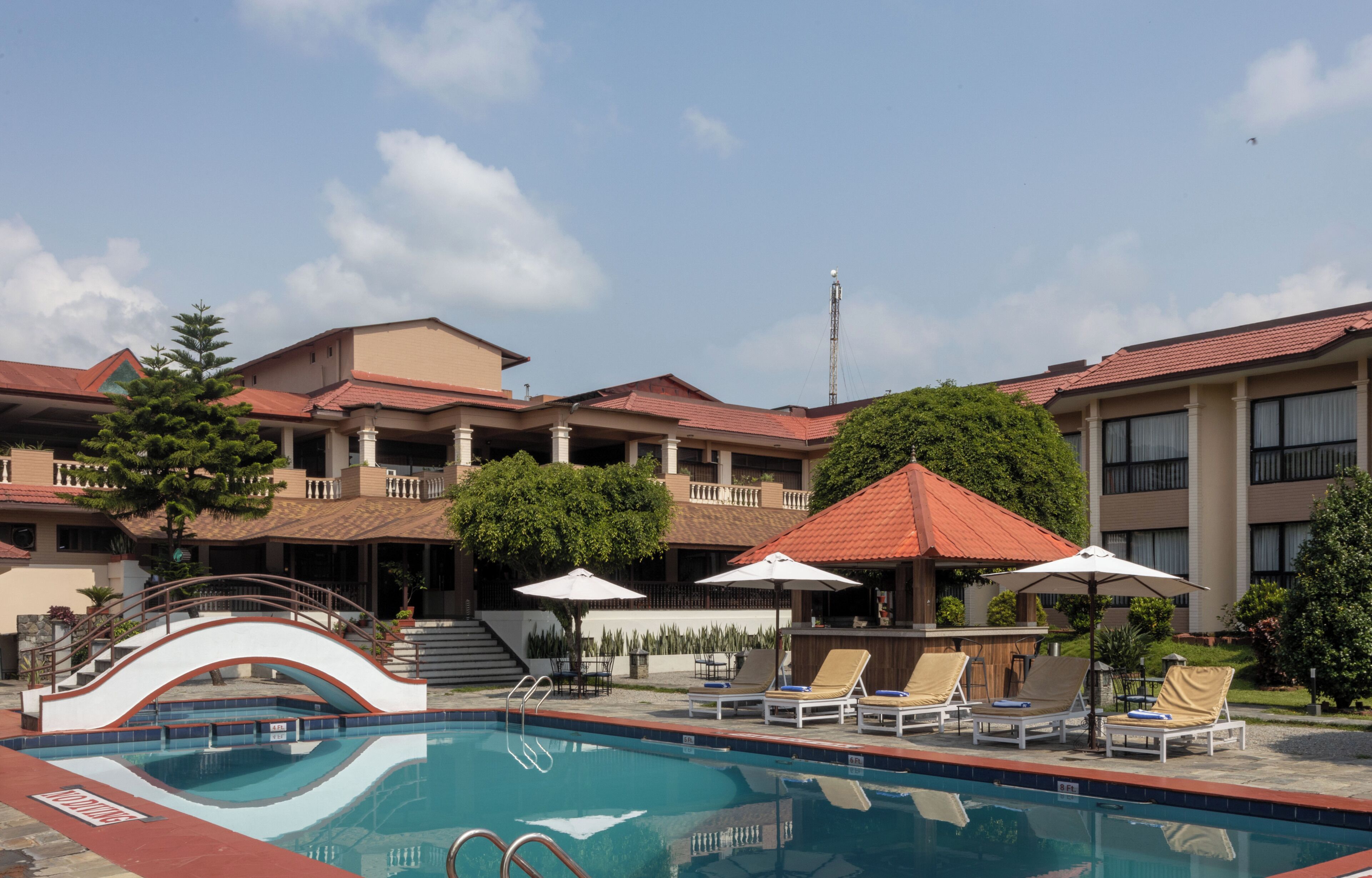 Un hôtel doté d’une piscine, de chaises longues et de parasols.