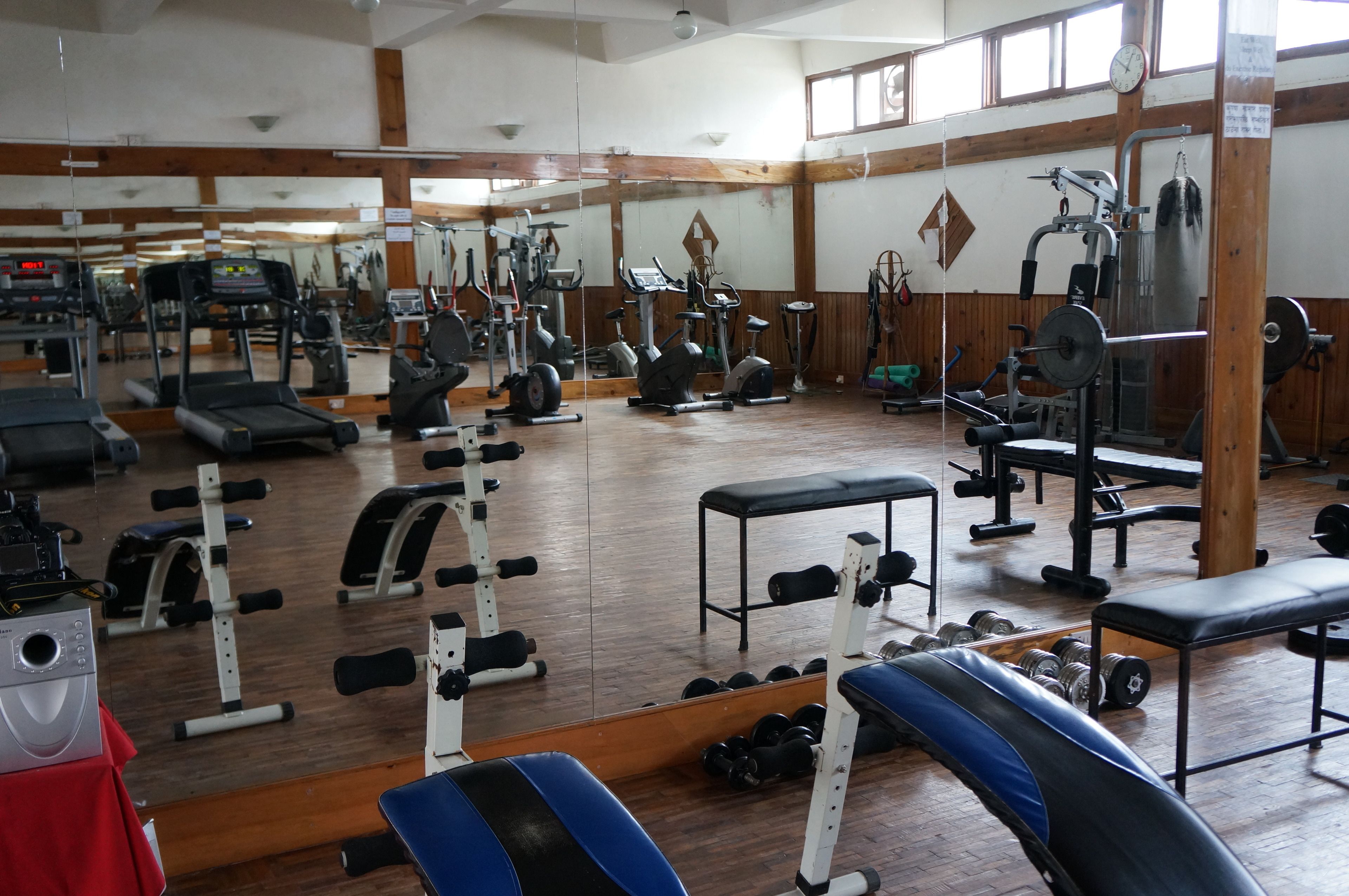 A gym with various exercise equipment, including treadmills, stationary bikes, and weight machines.