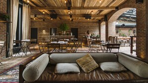 Um restaurante acolhedor com teto de madeira rústica, assentos de couro e paredes de tijolo.
