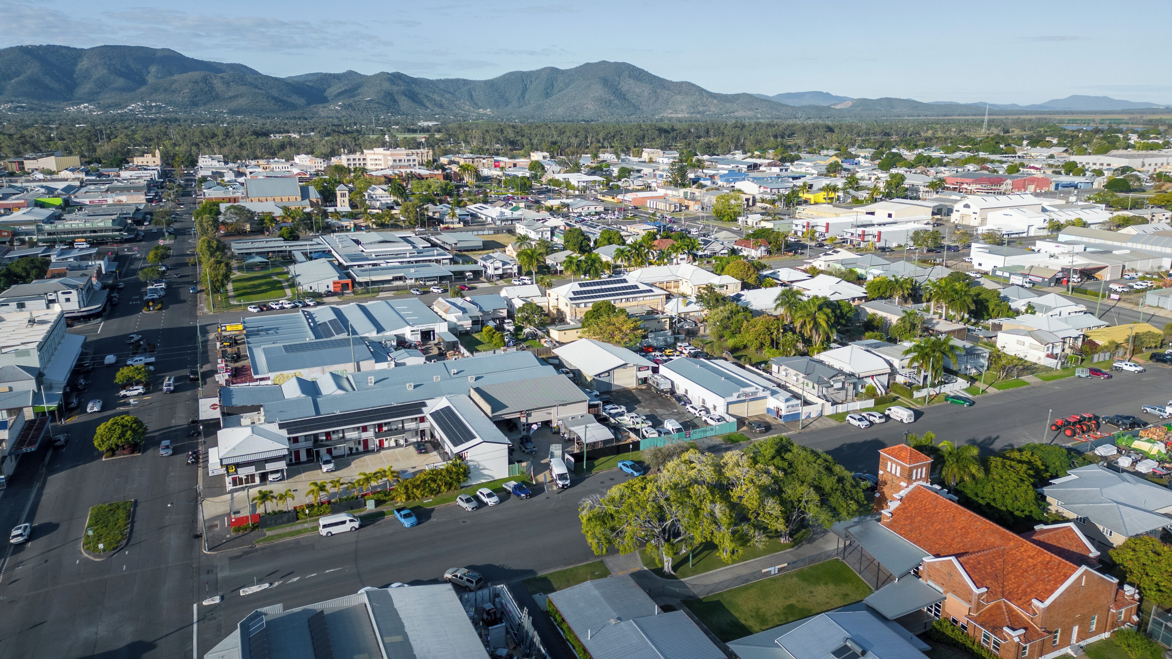 An aerial view of a town with various buildings, roads, and greenery.