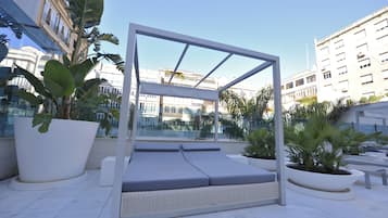 Una piscina al aire libre, sillones reclinables de piscina
