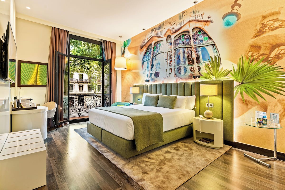 Ein modernes Hotelzimmer mit einem großen Bett, einem Schreibtisch und Blick ins Freie.