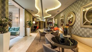 A modern hotel lobby with a curved ceiling, a seating area with a round table, and a sofa. - Hotel Indigo Barcelona - Plaza Catalunya by IHG (Barcelona)