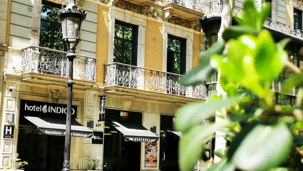 A hotel facade with ornate balconies, a street lamp, and signage for 'hotel INDIGO' and 'DOO RESTAURANT'. - Hotel Indigo Barcelona - Plaza Catalunya by IHG (Barcelona)