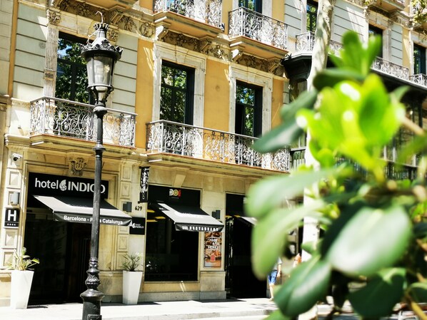 A hotel facade with ornate balconies, a street lamp, and signage for 'hotel INDIGO' and 'DOO RESTAURANT'. - Hotel Indigo Barcelona - Plaza Catalunya by IHG (Barcelona)