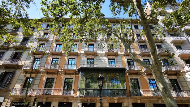 A multi-story hotel with balconies, a central entrance, and signage for a restaurant and a spa. - Hotel Indigo Barcelona - Plaza Catalunya by IHG (Barcelona)