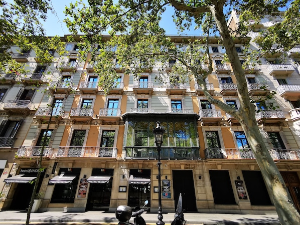 A multi-story hotel with balconies, a central entrance, and signage for a restaurant and a spa. - Hotel Indigo Barcelona - Plaza Catalunya by IHG (Barcelona)
