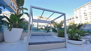 Una piscina al aire libre, sillones reclinables de piscina