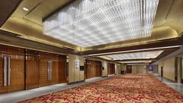 Un hall d’entrée spacieux, doté d’un tapis à motifs, de lambris en bois et d’un design moderne au niveau du plafond.