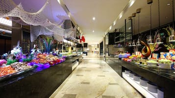 A buffet with various food items and a decorative net on the ceiling.