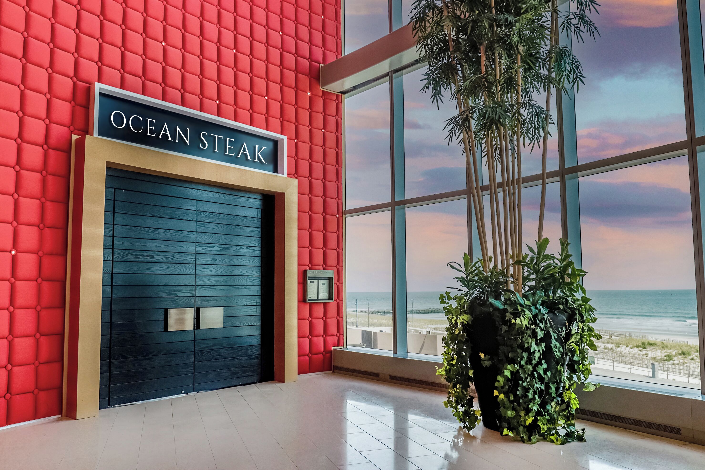 Un bâtiment moderne avec un mur rouge et une enseigne indiquant « OCEAN STEAK ».