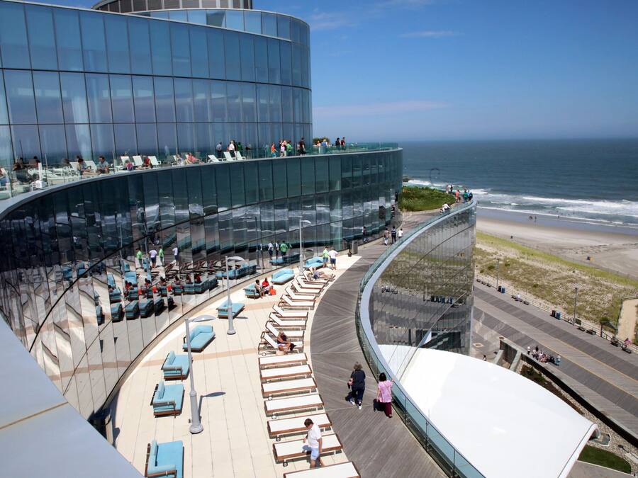 Et moderne hotel med en buet glasfacade med udsigt over stranden.