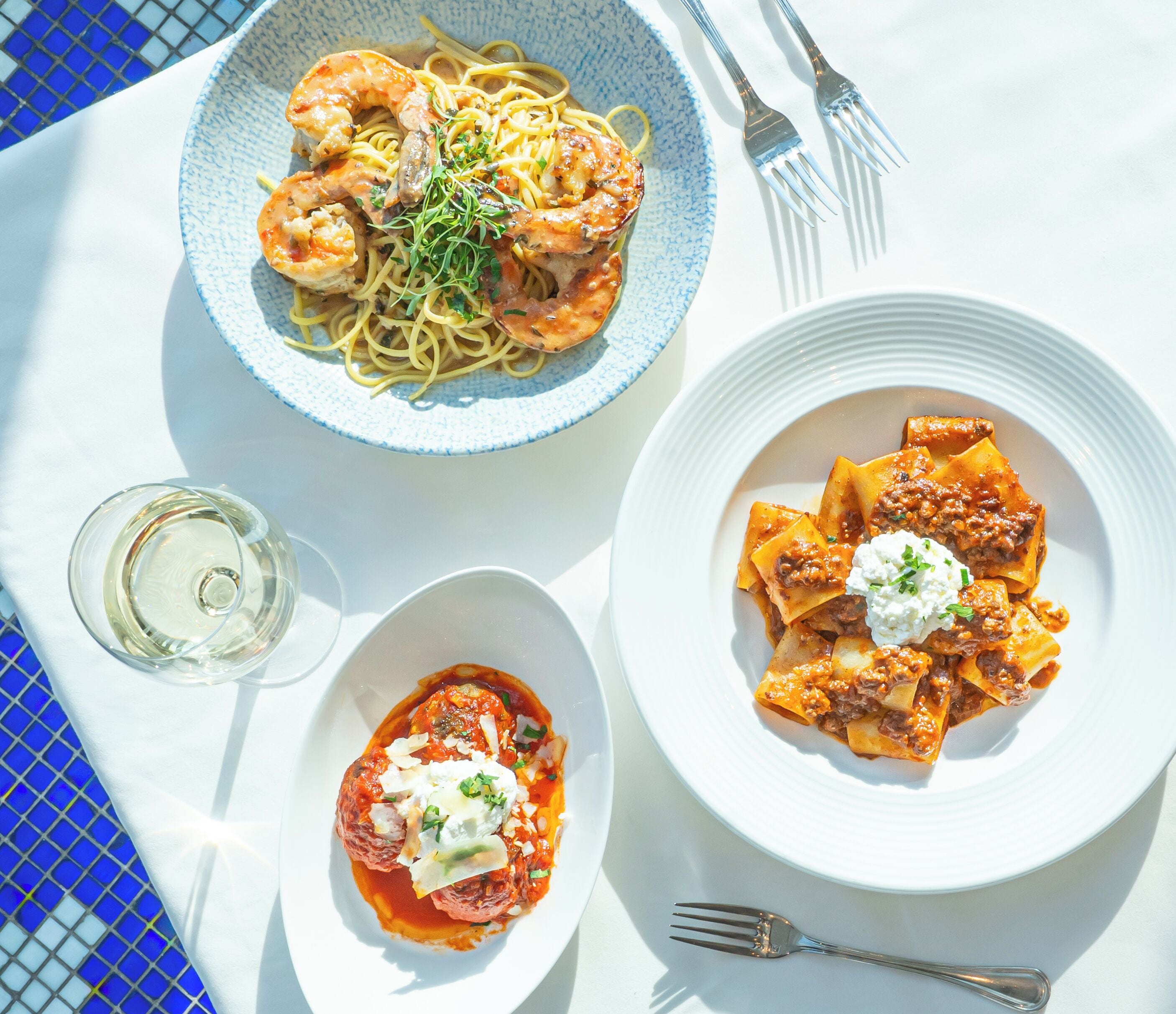 Tre piatti di pasta su un tavolo.