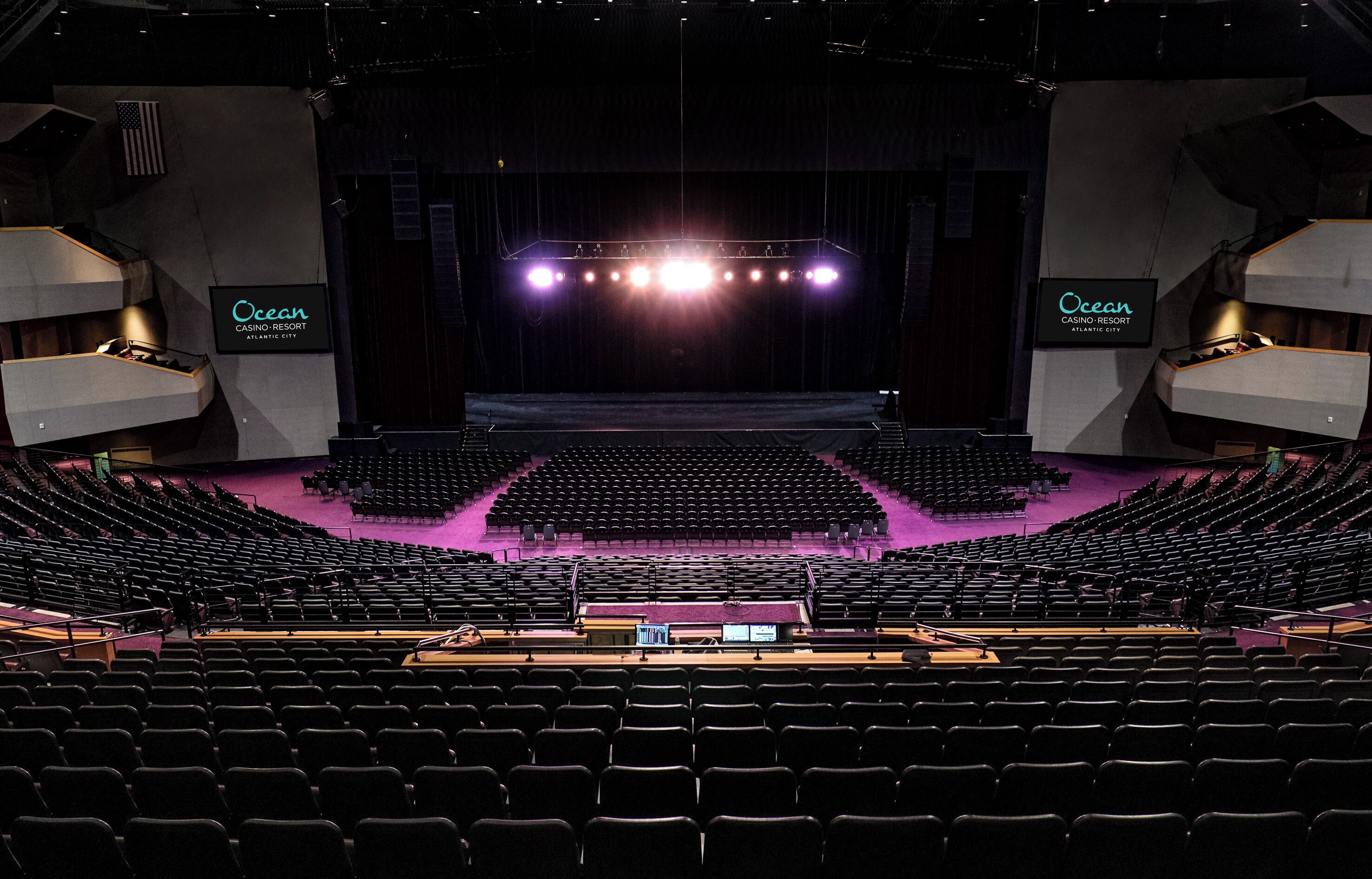 An indoor auditorium with rows of seats, a stage with lighting, and signage for Ocean Casino-Resort Atlantic City.