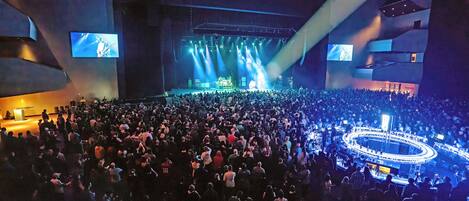 A large indoor venue with a stage and a crowd.