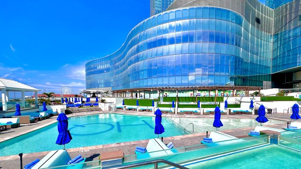 A modern hotel with a large outdoor pool, lounge areas, and a distinctive curved glass building. - Ocean Casino Resort (Atlantic City)