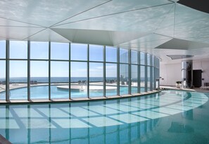 Une grande piscine intérieure avec vue sur l’océan, grâce à de larges baies vitrées.