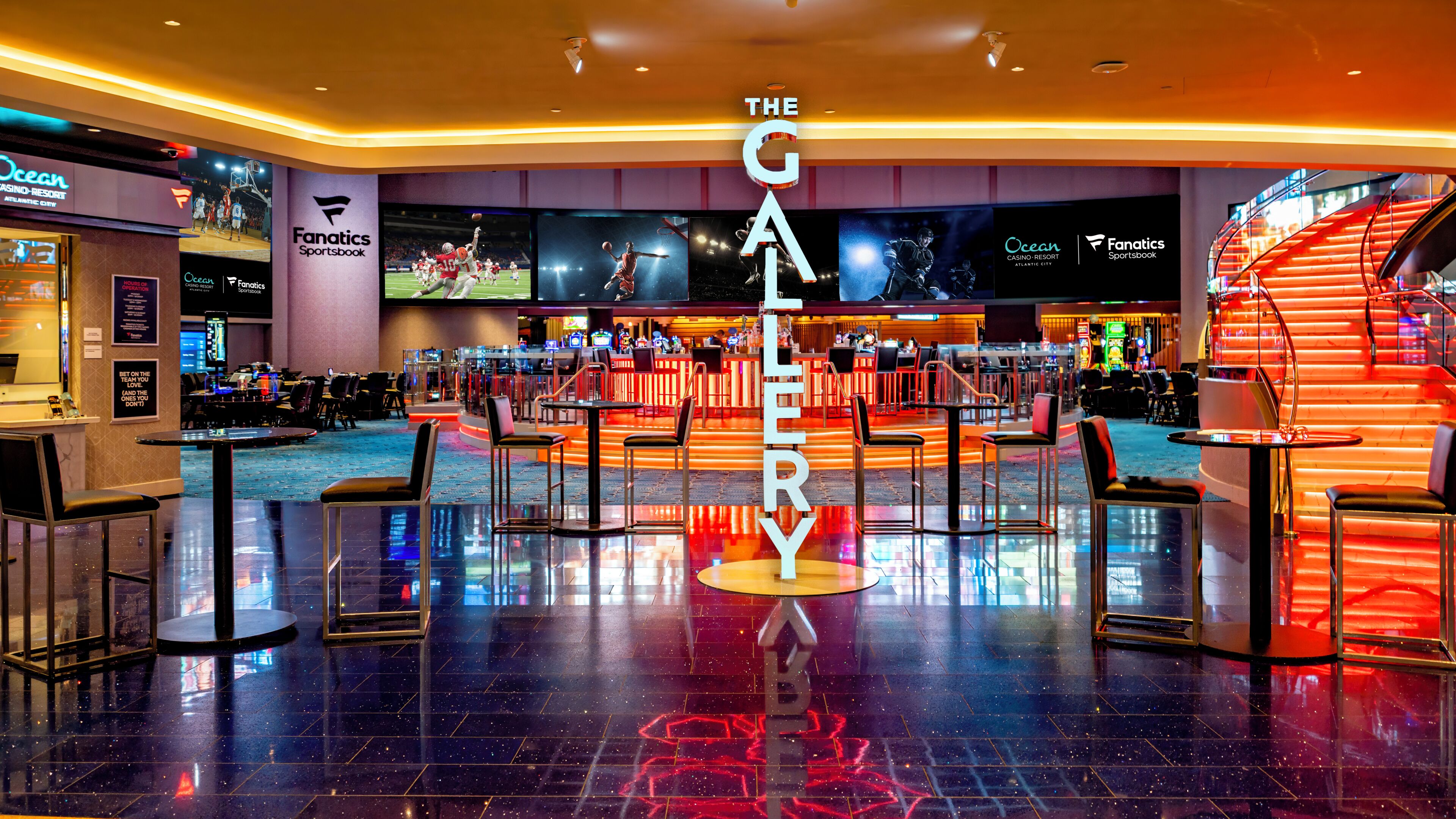 A spacious hotel lobby with a central bar area, multiple seating arrangements, and a prominent 'The Gallery' sign.