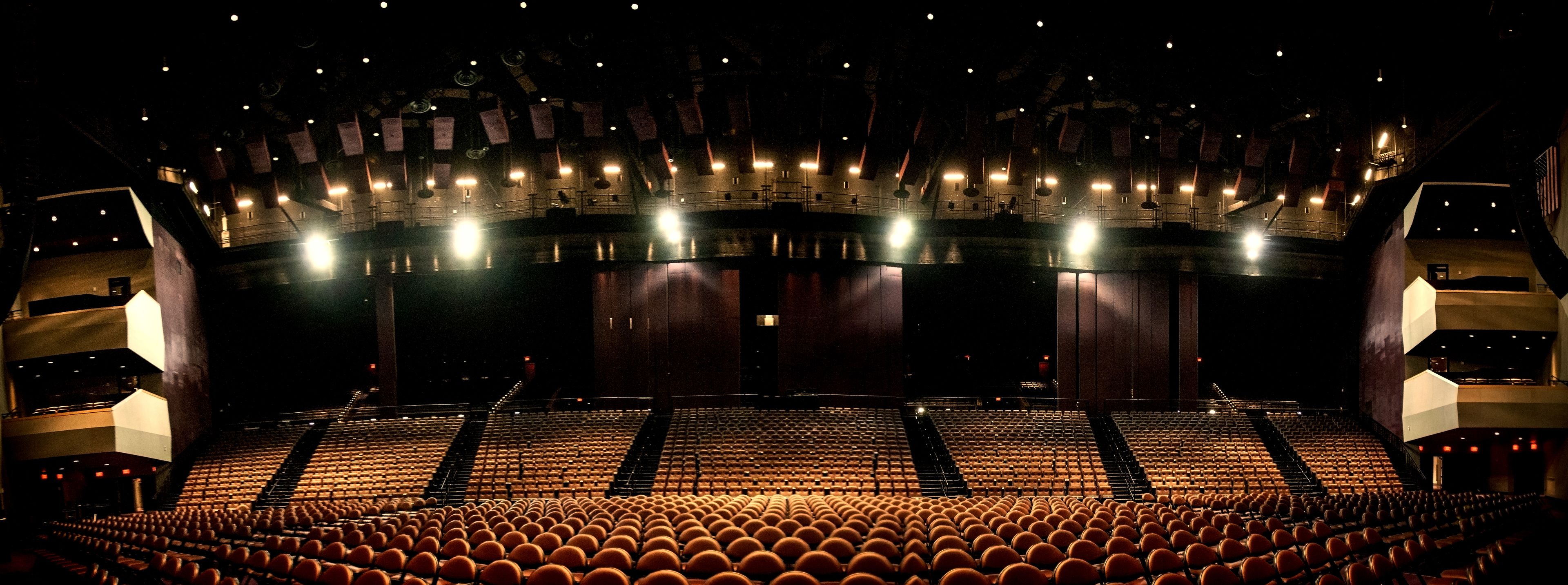 A large, modern theater with multiple levels of seating and a central stage.