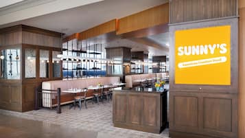 Un restaurante con paneles de madera, una isla central y un gran letrero amarillo.