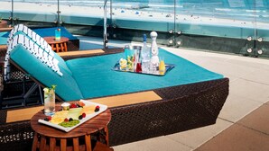 A rooftop bar with a view of the beach, outdoor seating, and a table with drinks and snacks. - Ocean Casino Resort (Atlantic City)