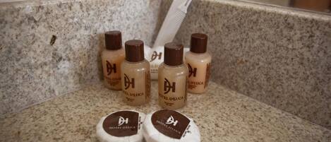 Una encimera de baño con artículos de aseo, incluyendo botellas y un peine.