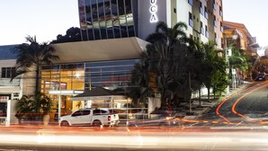Un hôtel moderne doté d’une façade en verre remarquable et d’une enseigne indiquant « HÔTEL D’LUCA ».