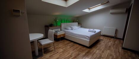 Un dormitorio con tragaluz, una cama, un escritorio y una silla.