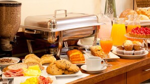 A buffet with various breakfast items including pastries, fruits, and beverages. - Hotel Centro Naval (Buenos Aires)