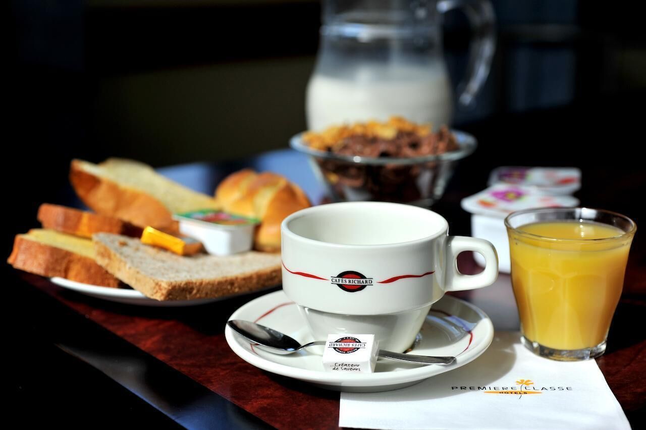 A breakfast setting with a cup of coffee, a glass of orange juice, and a plate of toast and cereal.