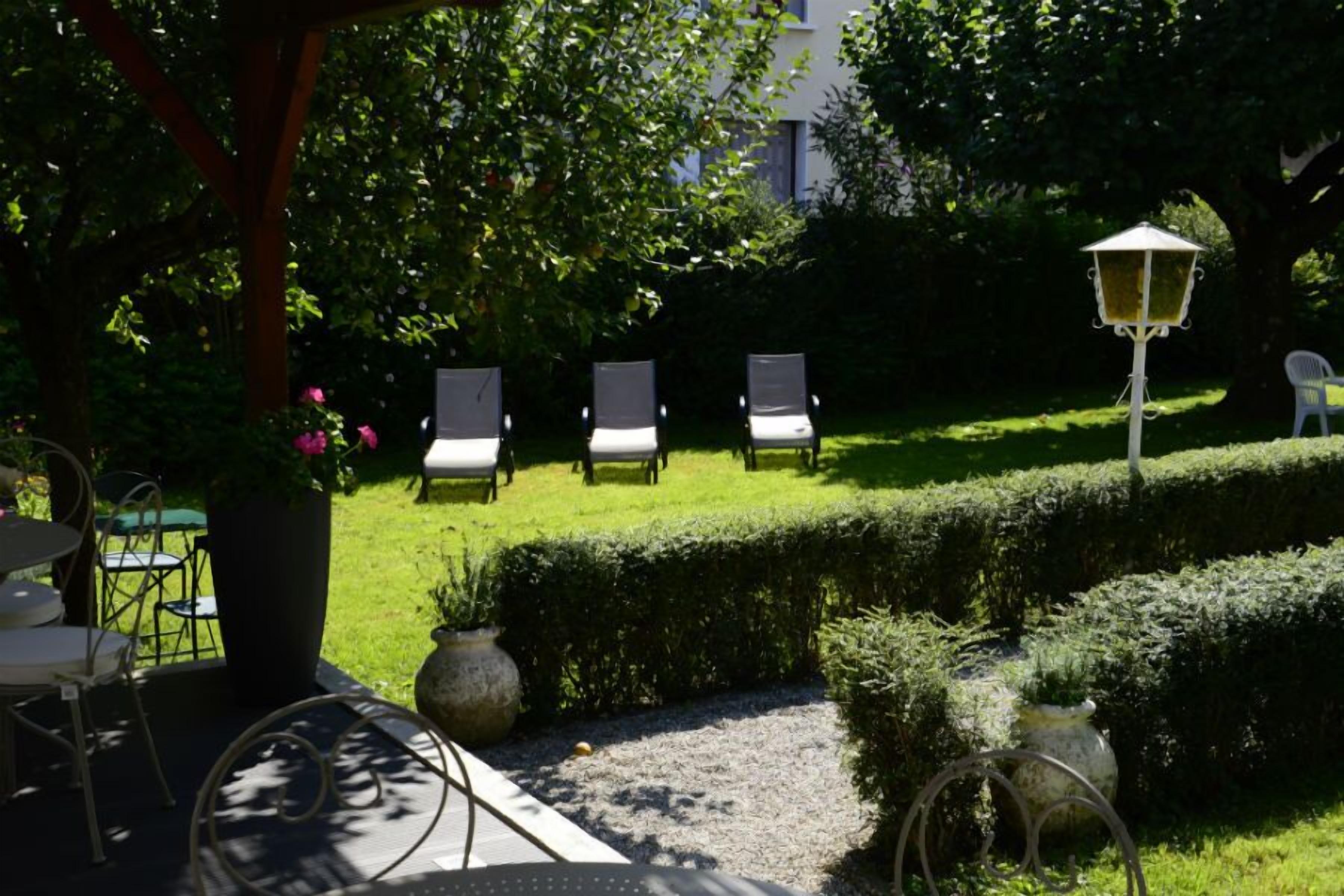 Un espace jardin aménagé avec des sièges extérieurs et un lampadaire.