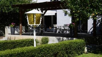 Un patio con mobiliario exterior, una pérgola y un farol decorativo.