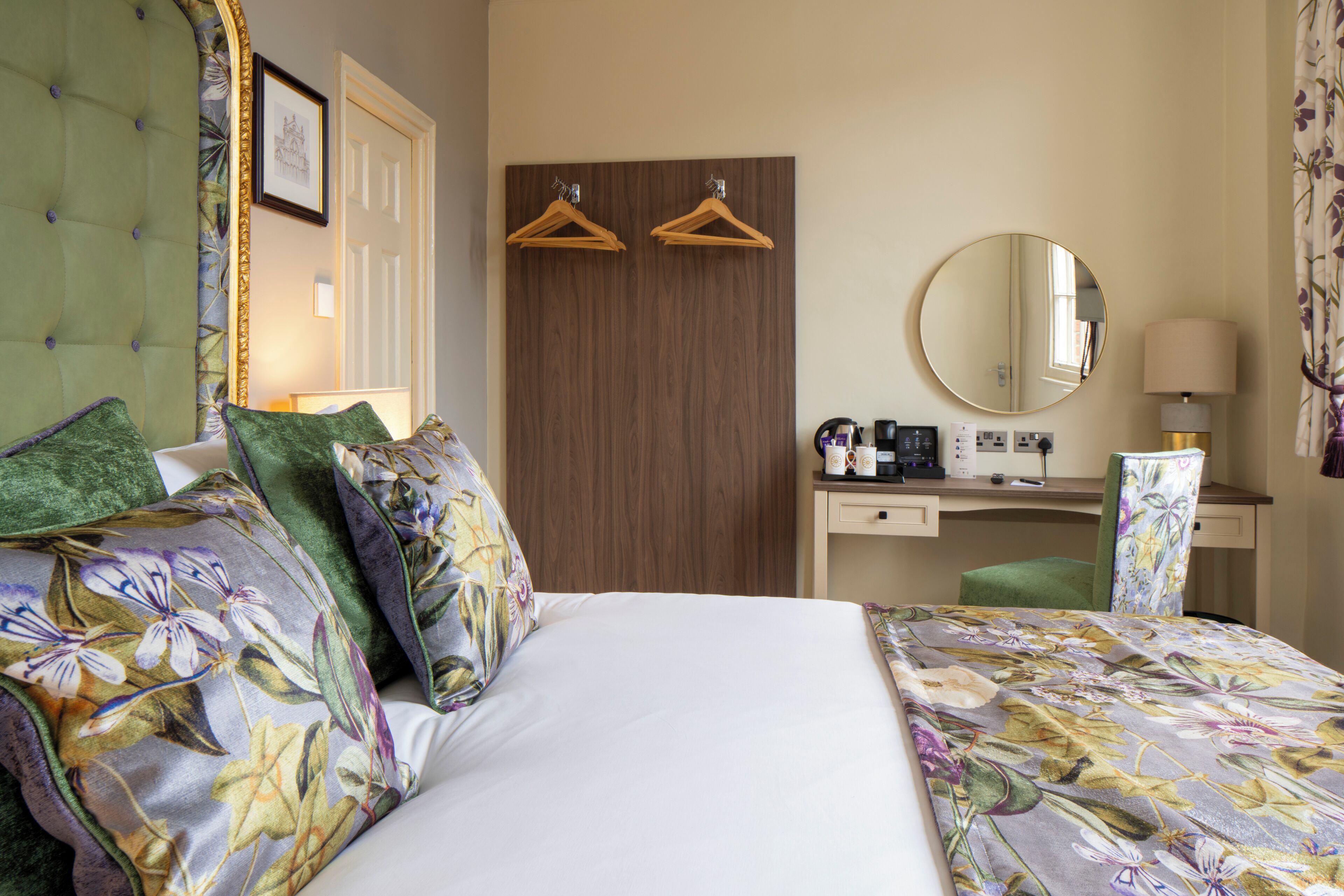 Une chambre d’hôtel comprenant un lit, un bureau, une chaise, un miroir et une armoire.